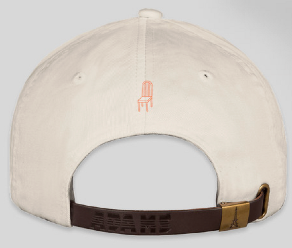 sunday tavola chair logo in orange stitched onto the back of beige baseball hat 