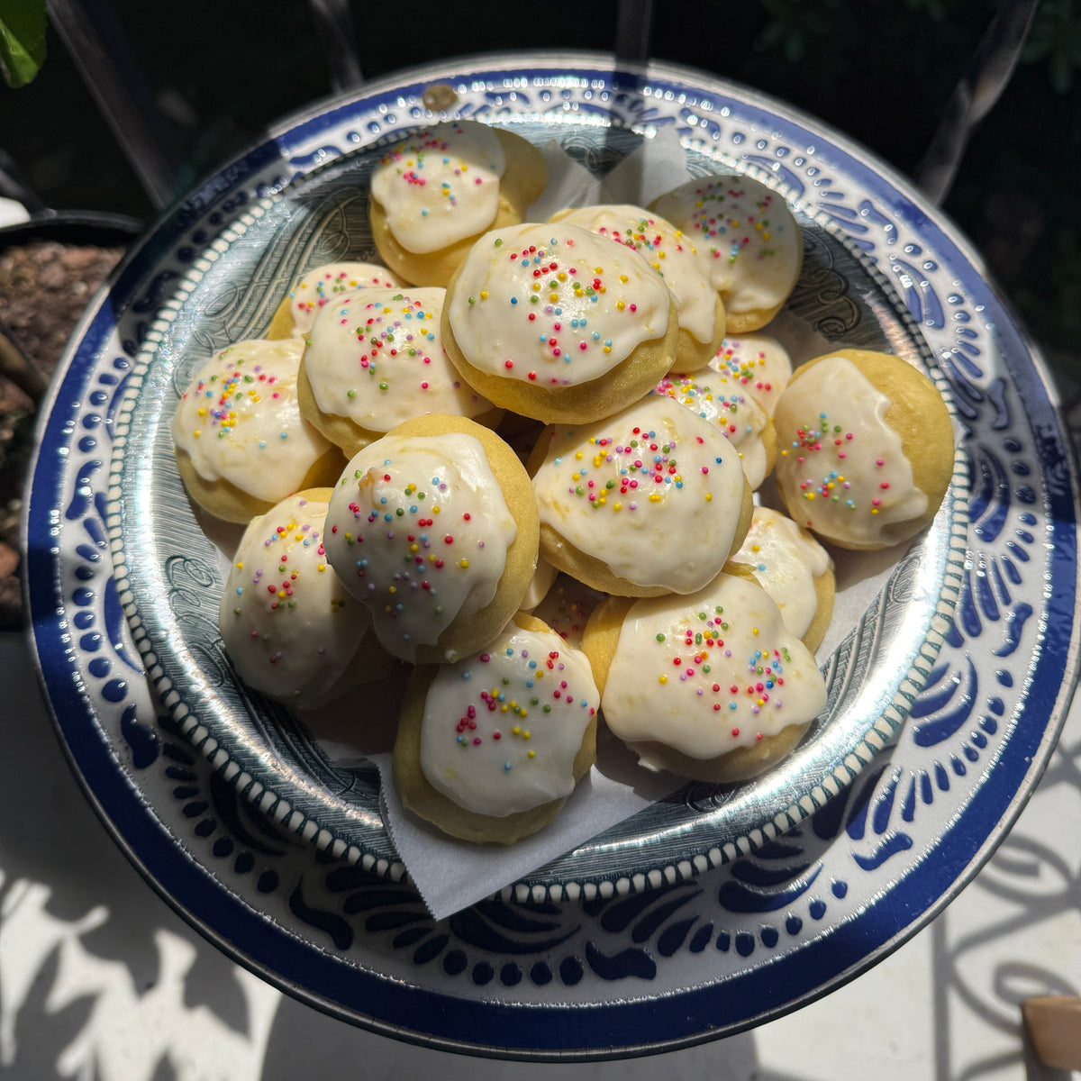 platter of sunday tavola anginetti cookies on a decorative ceramic blue and white table in the sunlight